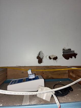 Air sampling pump inside a ceiling cavity with concealed mould growth on the sheeting behind it