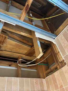 Inside an opened ceiling space showing an original raked ceiling that was framed over during a renovation