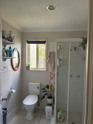 A home bathroom with a shower and a window but no exhaust fan or mechanical ventilation