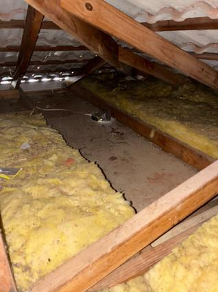 Roof space with insulation batts displaced and out of position, leaving bare sections of ceiling lining between them