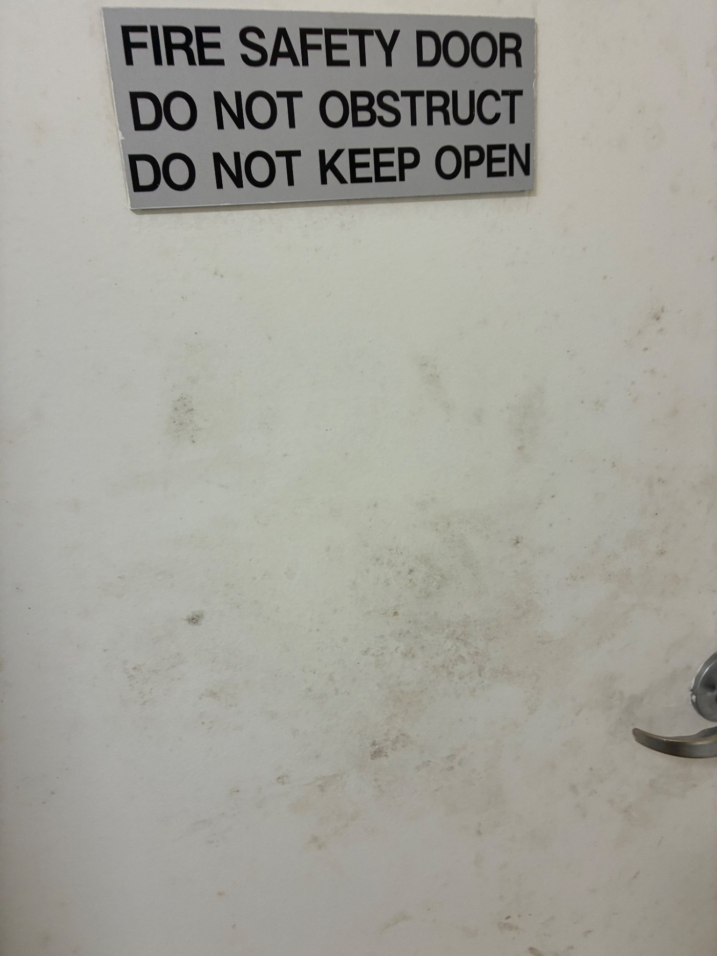 The sign is the problem and the reason for it in one photo. A door that cannot be kept open is a space that cannot ventilate itself.